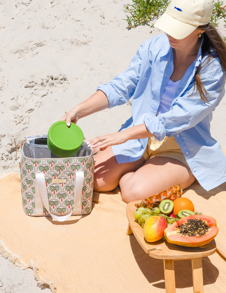 MontiiCo Insulated Midi Cooler Bag - Coconut Palms displayed outdoors for picnic or travel use