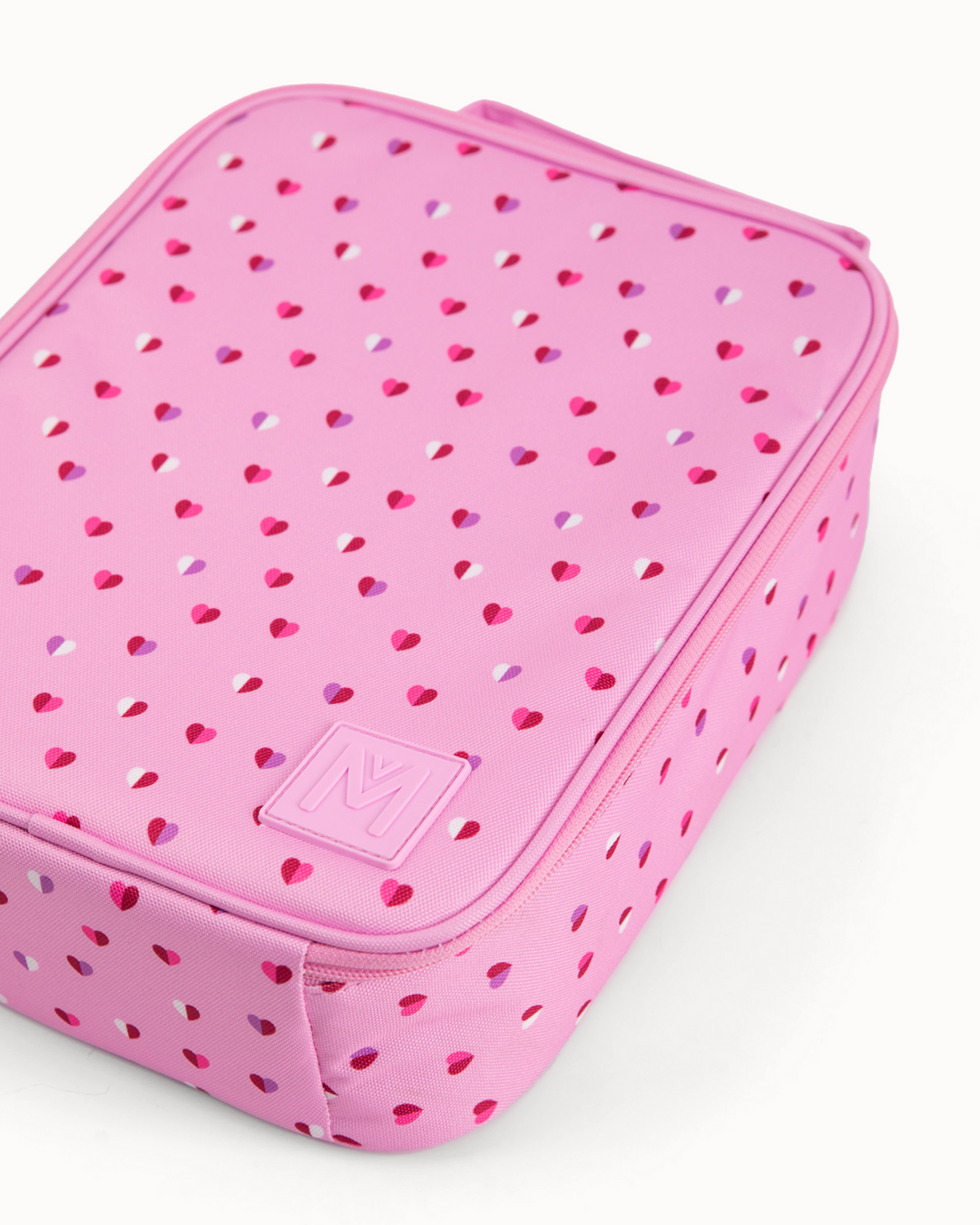 Pink lunch bag with heart patterns and a visible MontiiCo logo on a white background