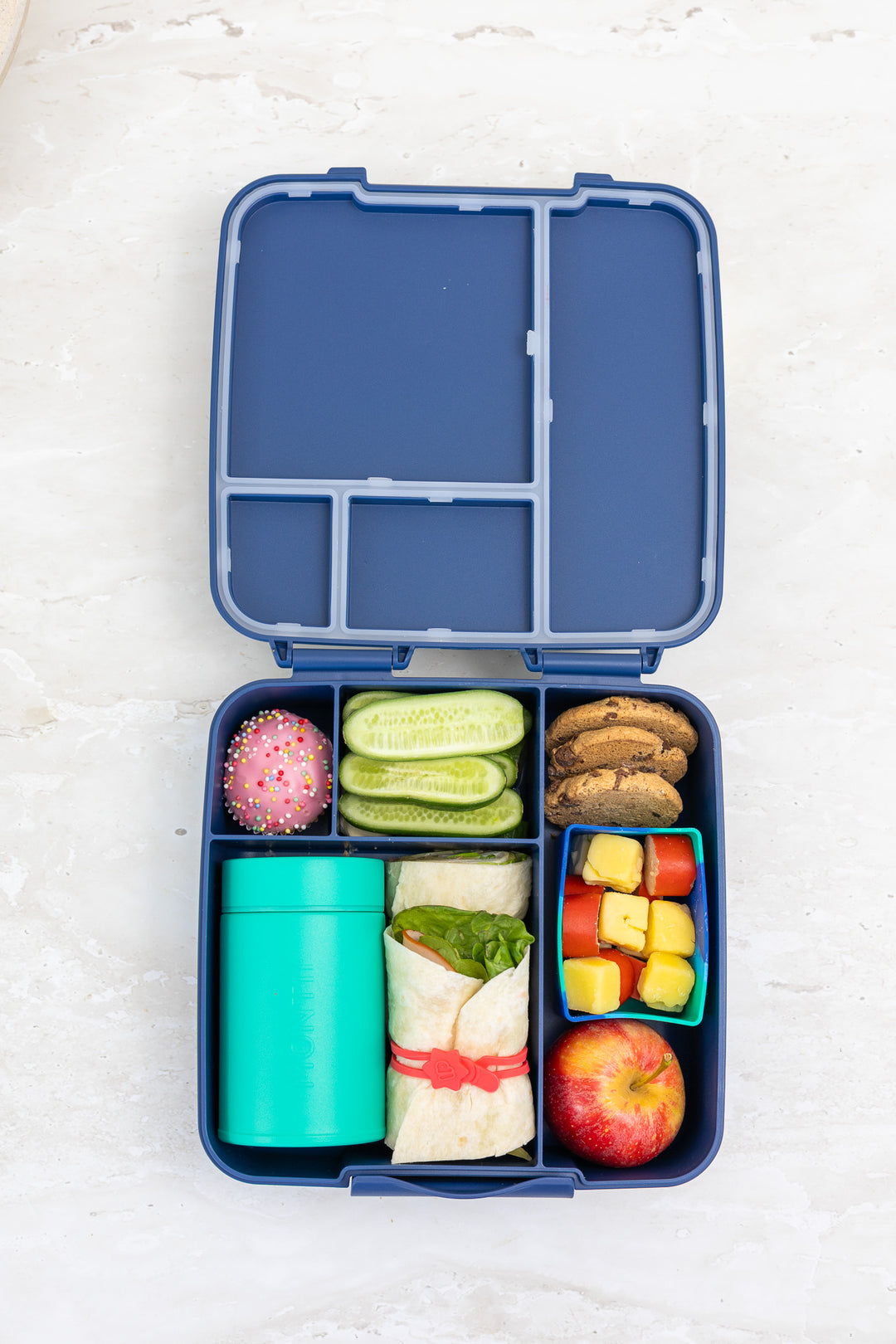 Insulated food thermos in lunchbox with fruit and snacks