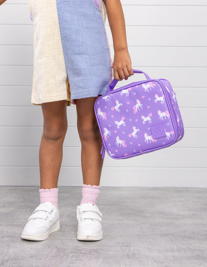 MontiiCo Medium Lunch Bag - Unicorn with child holding the bag standing
