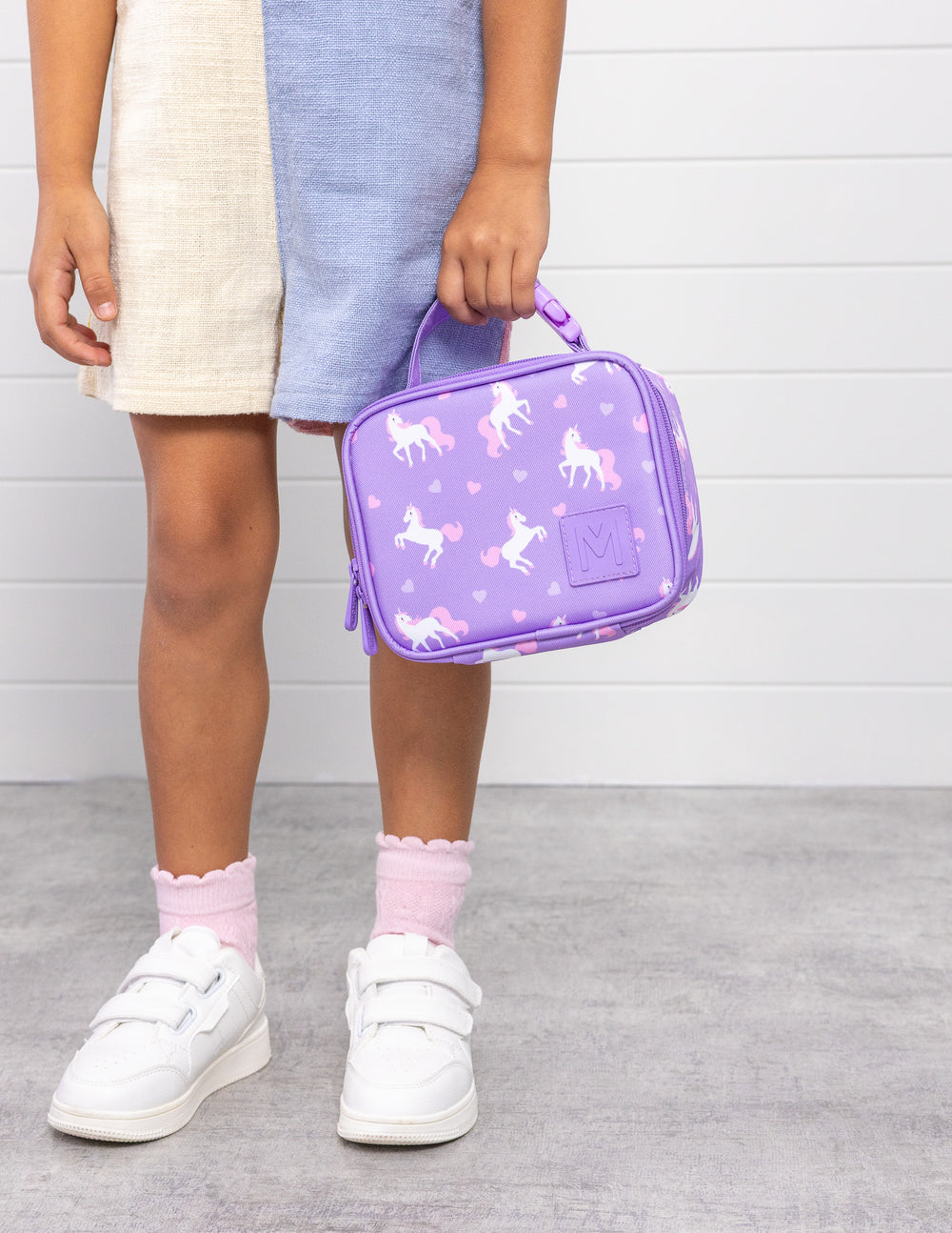 MontiiCo Mini Lunch Bag - Unicorn child holding the bag standing