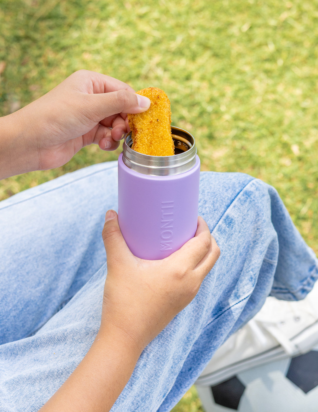 Child holding thermos snack pot for school lunch