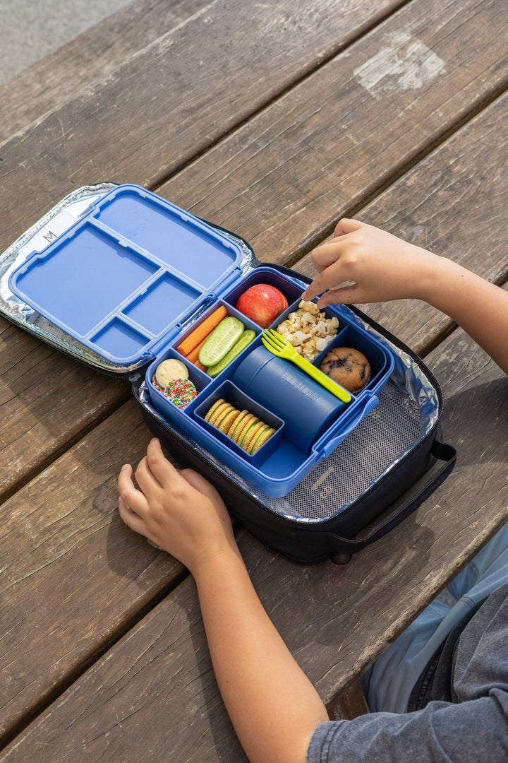 Insulated food thermos in lunchbox with fruit and snacks
